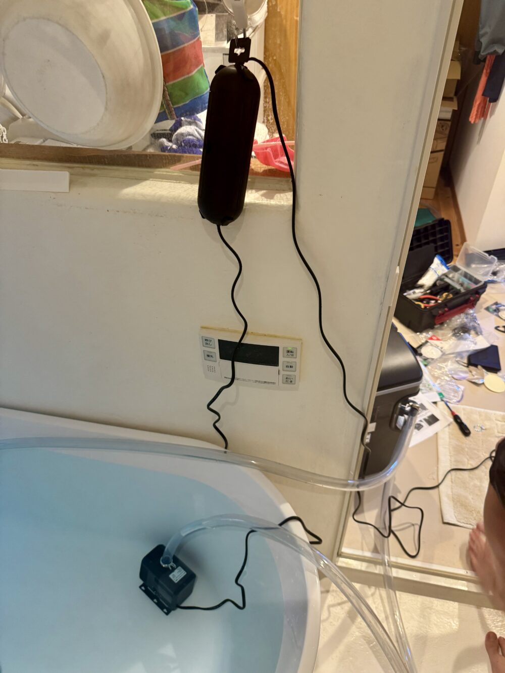 循環ポンプの接続部を防水コンセントボックスに収めて吊り下げた状態